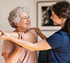 Nurse helping woman stretch arm across her chest