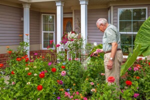 Man watering plants outside of his house