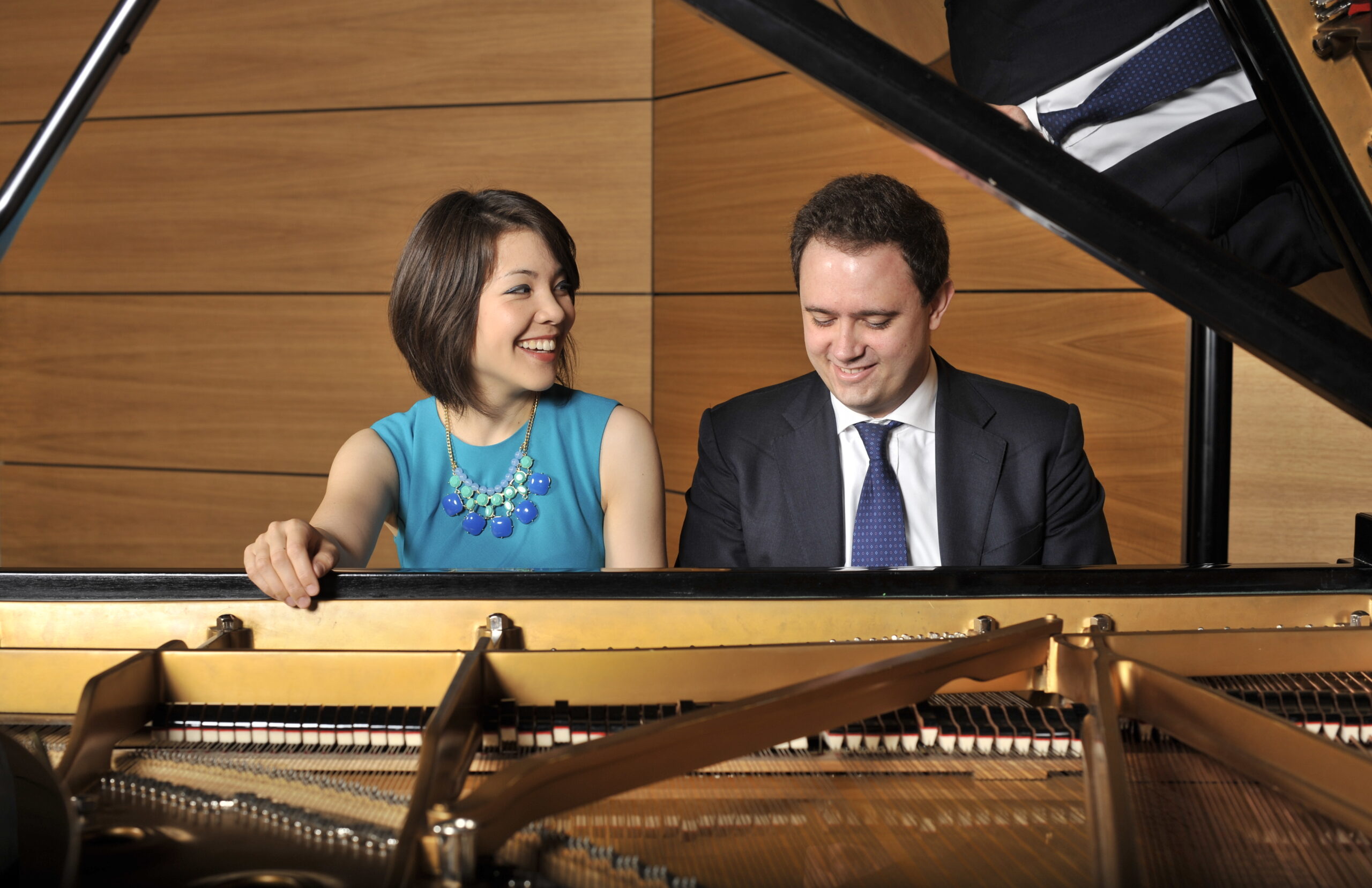 Man and woman sitting at a piano playing together
